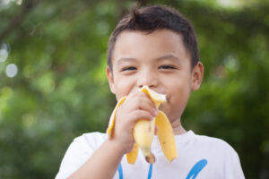 Young boy eating a banana